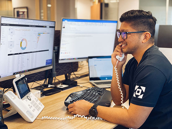 A Servcorp team member provides real-time IT support over the phone while monitoring multiple systems